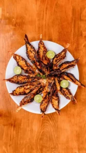 Blistering hot Camarones Cucarachas (crispy fire-grilled shrimp) served with fresh lime wedges at Unos Mariscos O Que in Round Rock, TX.