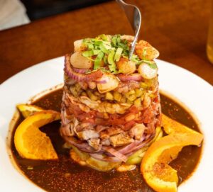 Authentic Sinaloa-style Torre de Mariscos (Seafood Tower) drenched in signature salsa negra, served at Unos Mariscos O Que in Round Rock, TX.